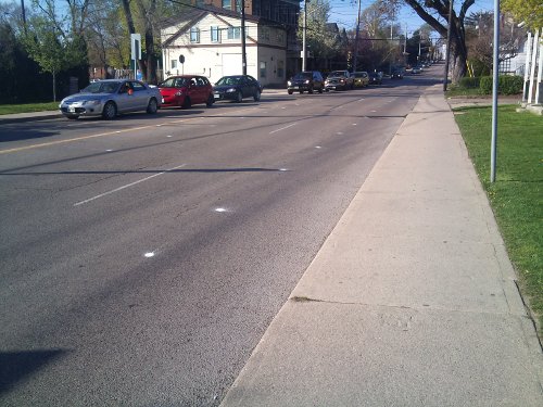 Paint spots on Dundurn Street North mark the location of the upcoming bike lanes (Image Credit: Joey Coleman)