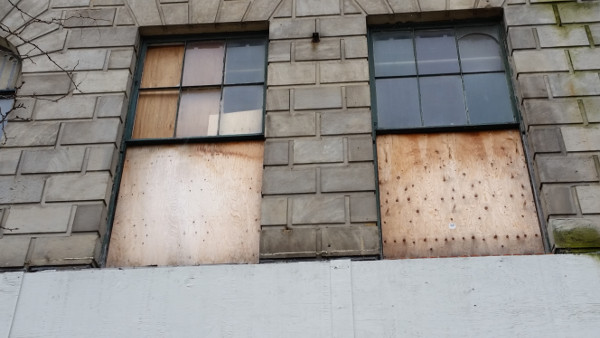 Broken windows covered with plywood