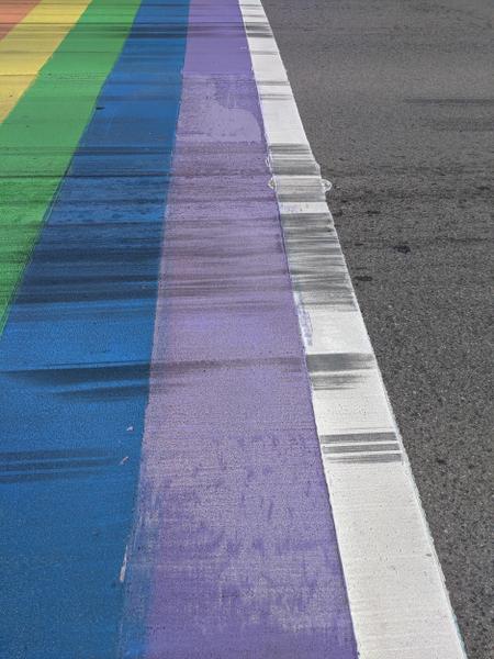 More detail of rainbow crosswalk faded and covered in skid marks (Image Credit: Cameron Kroetsch)