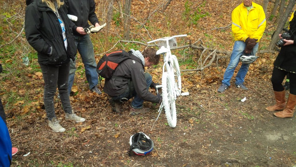 Andrew Hibma locking the ghost bike (Image Credit: Jeffrey Neven)