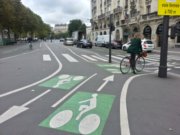 Raised curbs, clear markings for bike lanes through an intersection