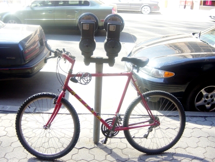 Bicycle parked against a parking meter