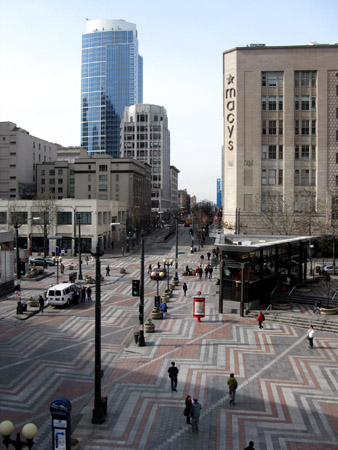 It's early morning on a Saturday, yet the hustle and bustle is already beginning. Note the woonerf sidewalks and brickwork creating a pedestrian-oriented design across the roadway. 