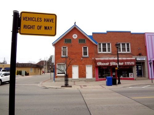 Sign at crosswalk reads: 'VEHICLES HAVE RIGHT OF WAY'