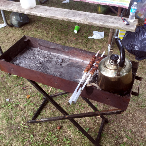 The family from Kurdistan is cooking barbecued skewers.